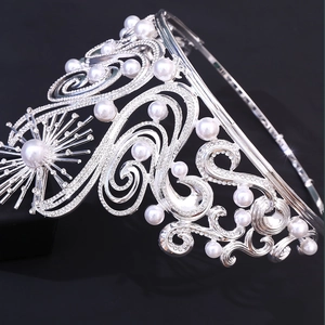 Detailed view of silver Baroque tiara with sparkling rhinestones and white pearls