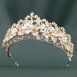 Close-up of luxury gold leaf bridal tiara with sparkling rhinestones on green velvet