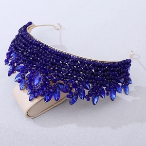 Détail d'un diadème de mariée doré avec perles de cristal bleu foncé et strass brillants