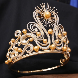 Detail of luxury gold crown with pearls and rhinestones on elegant black fabric background