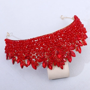 Détail d'un diadème de mariée doré avec grands cristaux rouges en forme de larme et perles