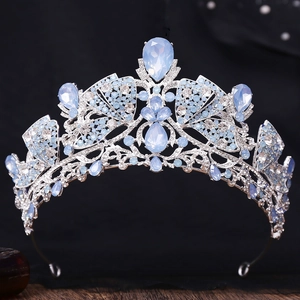 Macro shot of silver bridal crown with light blue gemstones and crystals on black velvet