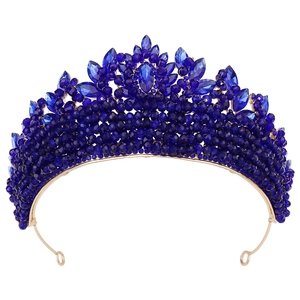 Détail macro d'une couronne dorée de luxe avec cristaux bleu foncé et perles élaborées