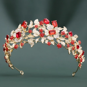 Detailed view of ornate gold bridal tiara with red crystals and floral metal patterns