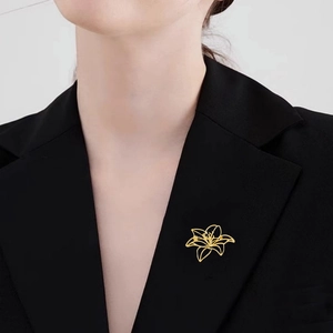 Elegant gold hollow lily brooch on black blazer lapel for sophisticated women accessories