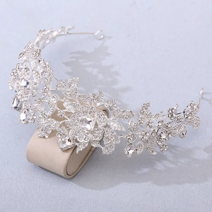 Detailed close-up of a silver bridal tiara with intricate flower patterns and clear crystals