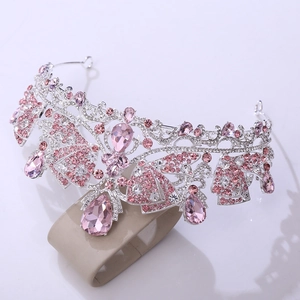 Close-up of pear-shaped pink crystal pendants and intricate silver tiara scrolls
