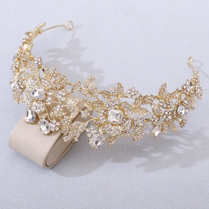 Detailed macro view of the golden floral tiara featuring intricate crystal leaf designs