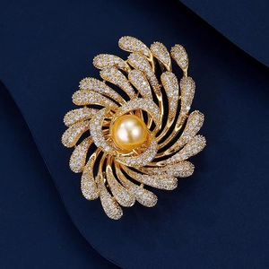 Lujoso broche de flor en espiral dorado con perla central y detalles de circón