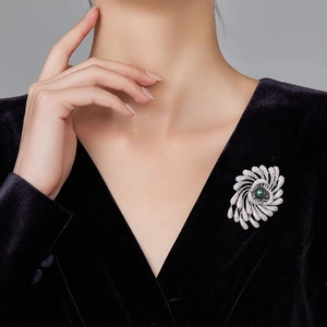 Vue détaillée d'une broche en argent avec perle noire sur une veste en velours noir