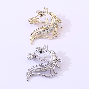 Détail de broches en forme de tête de cheval creuses dorées et argentées avec strass