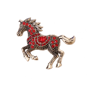 Broche de caballo vintage dorado con diamantes de imitación rojos en pose de carrera