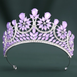 Close-up of baroque bridal crown with purple crystals and silver alloy base on green fabric