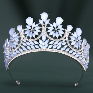 Close-up of silver baroque crown featuring blue crystal teardrops and white rhinestones