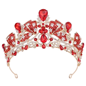 Close-up of golden baroque tiara with pear-shaped red rubies and white crystals