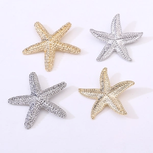 Set of four textured starfish brooches in gold and silver finish on white background