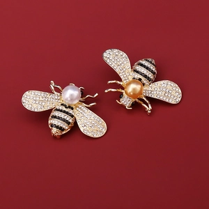 Elegante Bienen-Brosche mit Perlen und Kristallen auf dunkelrotem Hintergrund