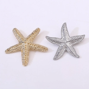 Detailed close-up showing gold and silver starfish brooches with fine metallic texture