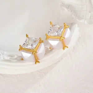 Minimalistische Zirkonia Ohrstecker mit goldenem geometrischem Rahmen und weißer Perlenbasis