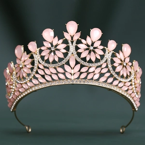 Macro detail of golden baroque crown with pink teardrop gemstones and white crystals