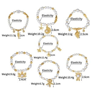 Détail de bracelets de perles élastiques avec des breloques dorées d'étoiles de mer