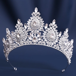 Macro shot of silver bridal tiara featuring teardrop crystals on deep blue velvet base