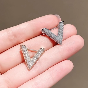 Minimalist V-shaped silver and rose gold stud earrings with paved crystals for women