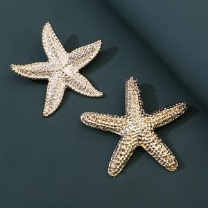 Close-up of golden starfish brooch with realistic textured detail and metallic finish