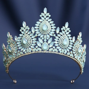 Detailed close-up of a gold bridal tiara featuring light blue crystals on a velvet backdrop
