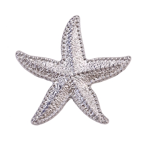 Close-up of vintage silver starfish brooch showing detailed textured alloy surface
