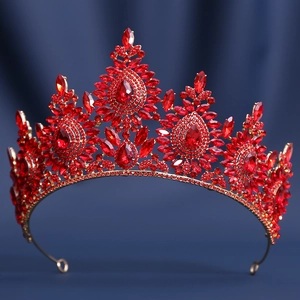 Detailed view of luxury gold alloy crown featuring red teardrop crystals on blue silk