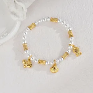 Détail d'un bracelet de perles avec breloques dorées en forme de tortue, coquillage et poisson