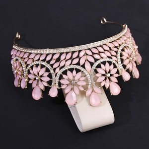 Detailed close-up of pink gemstones and white rhinestones on a gold bridal tiara