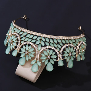 Detailed macro of golden baroque bridal crown with mint green gems and crystals