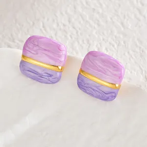 Vue détaillée de boucles d'oreilles carrées en résine marbrée avec barre dorée élégante