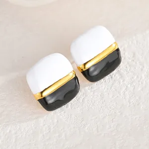 Gros plan de boucles d'oreilles carrées avec contraste noir et blanc et bordure dorée