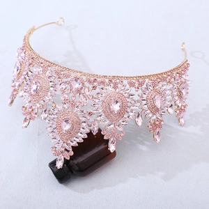 Close-up of pink crystal bridal tiara with gold alloy floral patterns and teardrop stones