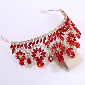 Detail of golden crystal crown with red teardrop stones and floral rhinestone pattern