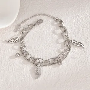 Détail d'un bracelet double couche argenté avec breloques feuilles et zircons fins