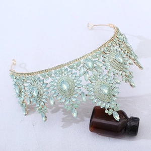 Detailed side view of baroque gold bridal crown with blue rhinestones and floral alloy patterns