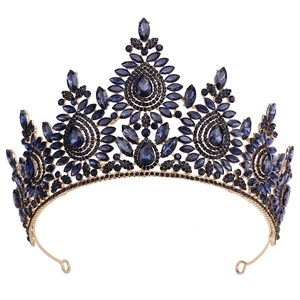 Close-up of golden baroque bridal tiara with deep blue crystals and intricate rhinestones