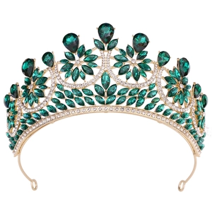 Close-up of golden alloy bridal crown with deep green crystals and white rhinestones