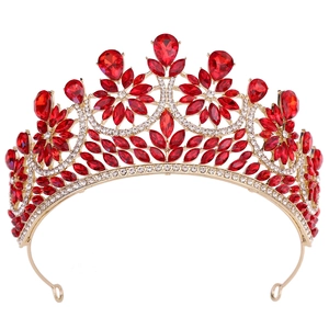 Close-up of golden bridal crown with red teardrop crystals and sparkling rhinestones