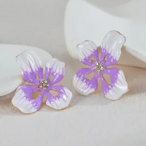 Detailaufnahme der violett-weißen Emaille-Blumenohrringe mit funkelnden Kristallzentren