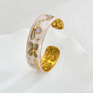 Macro view of gold vintage cuff bracelet with pink marble enamel and floral relief details