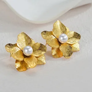 Elegante goldene Blumenohrringe mit weißen Perlenzentren und gebürsteter Metallstruktur