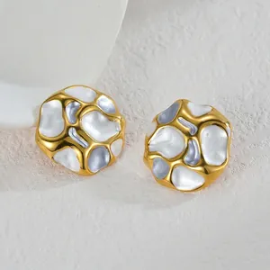 Macro detail of irregular crinkled gold earrings with blue and white enamel drip glaze