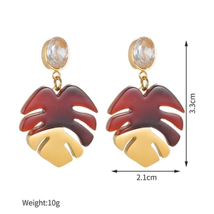 Detail view of monstera leaf earrings showing 3.3cm length and gold-resin finish
