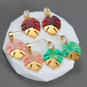 Three pairs of tropical monstera leaf earrings with colorful resin and gold metal details
