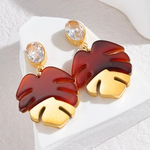 Detail of Monstera leaf earring with red resin, gold metal and crystal stud